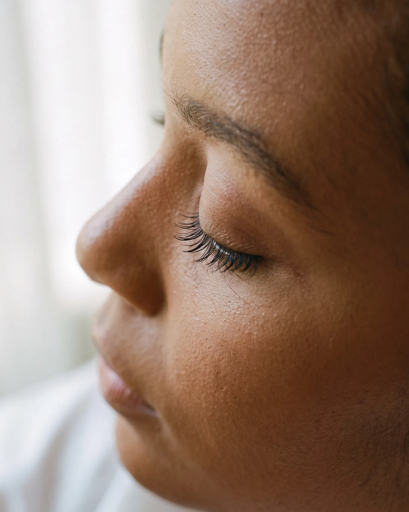 Profile close-up of a closed eye with lifted, defined natural lashes
